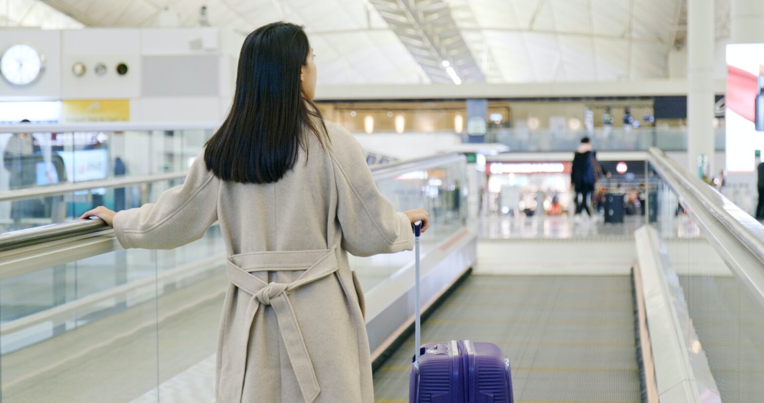 Woman walking with the luggage in the airport